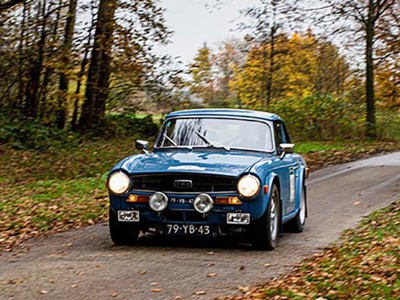 Triumph Tr4 rijd op een bosweg